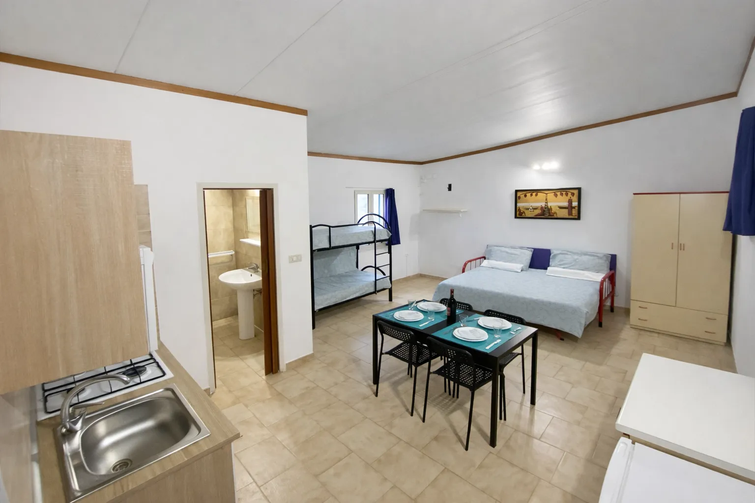 Interno monolocale del Villaggio Vieste Marina con cucina e posti letto nel Gargano